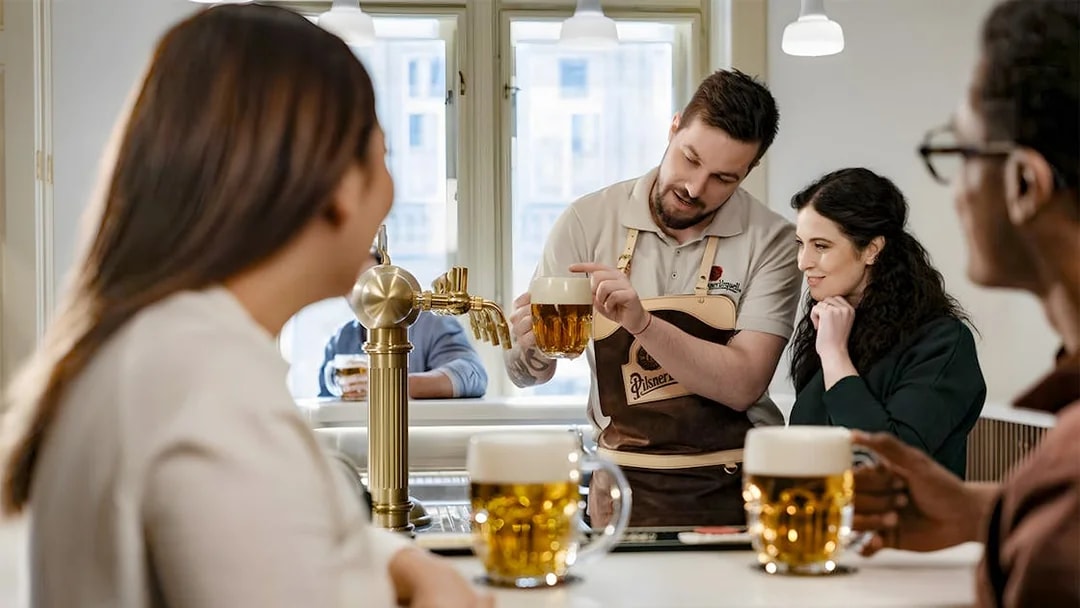 Tapster demonstrating beer pouring technique at Pilsner Urquell experience.