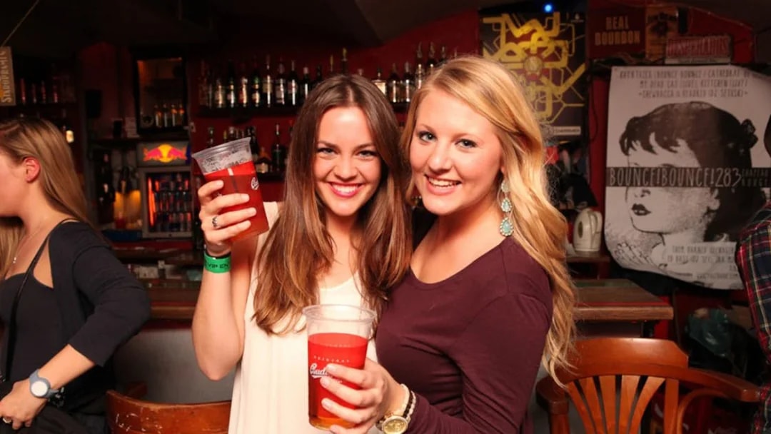 Two people enjoying drinks at a bar during a Prague pub crawl.