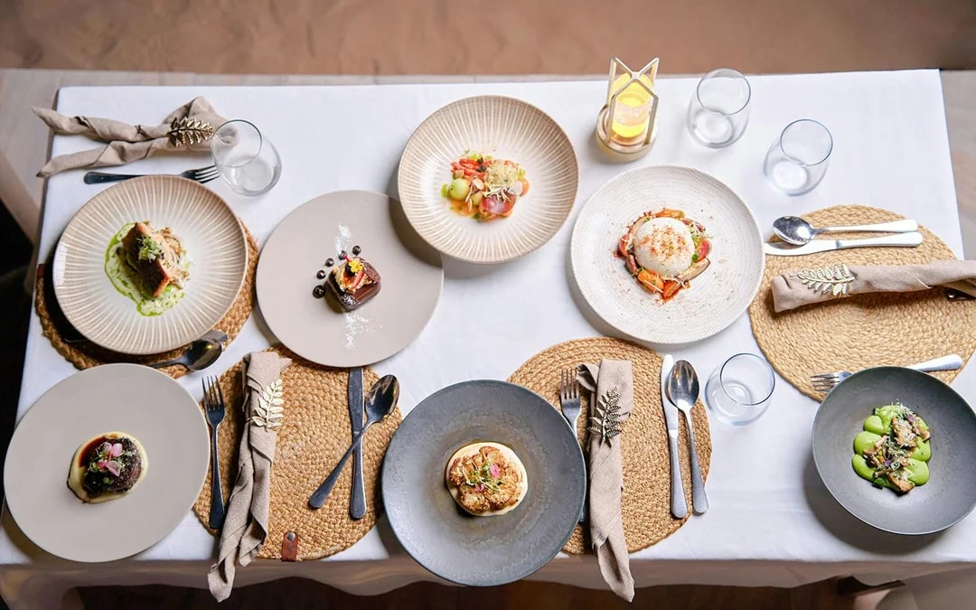 Meal setup at Noble Camp Desert Safari with various gourmet dishes on a table.