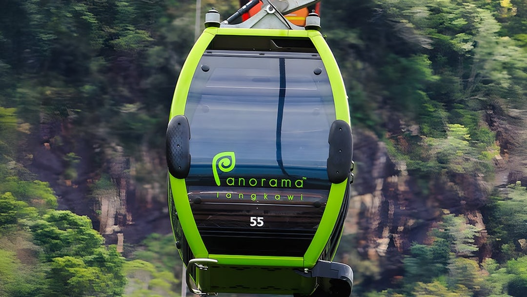 Private gondola on Langkawi cable car with forested hills in the background.