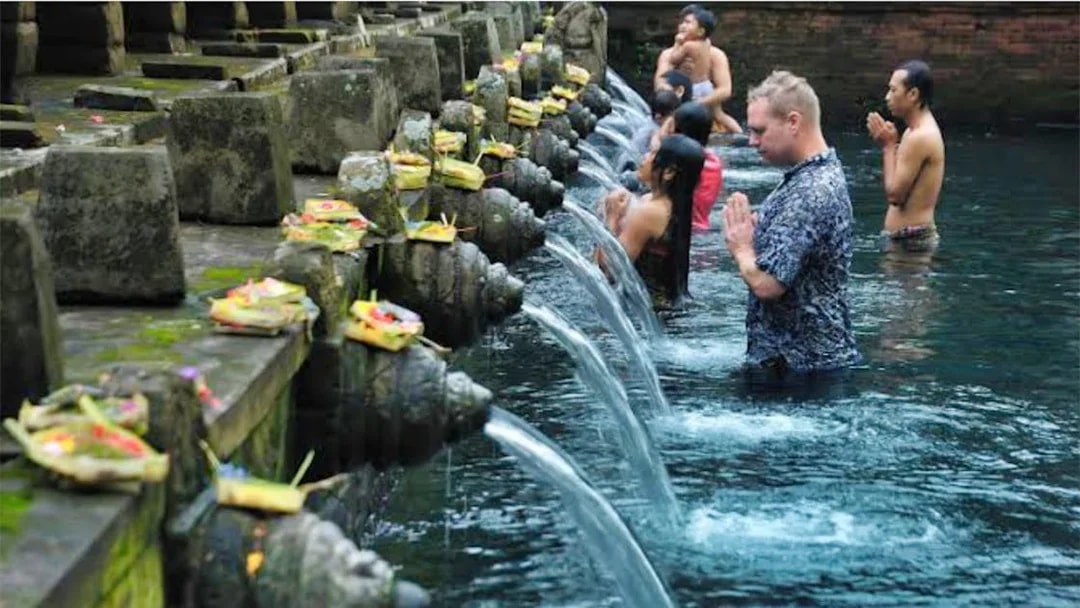 Visitors participating in a purification ritual at Tirta Empul Temple, Bali.