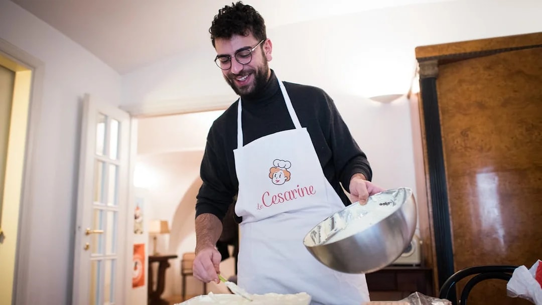 Man preparing dish during private cooking class in Bologna kitchen.