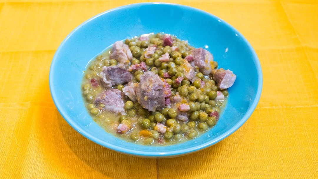 Bowl of traditional Italian peas and pork stew from a cooking class in Bologna.