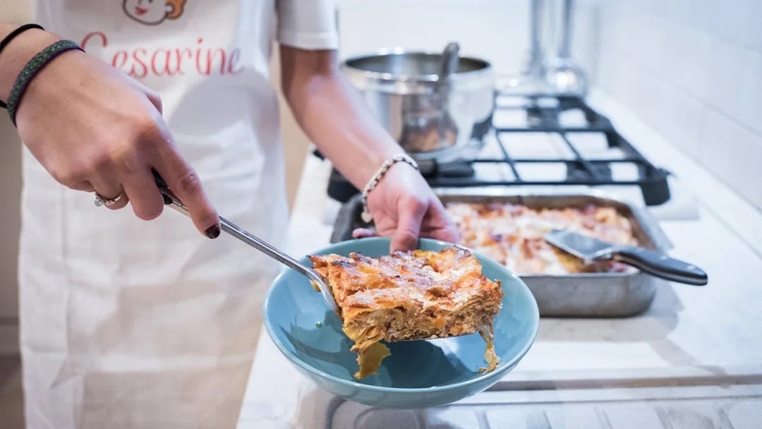 Serving homemade lasagna during a private cooking class in Bologna.