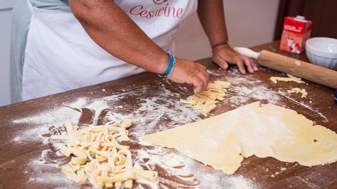 Person preparing fresh pasta during a private cooking class in Milan.