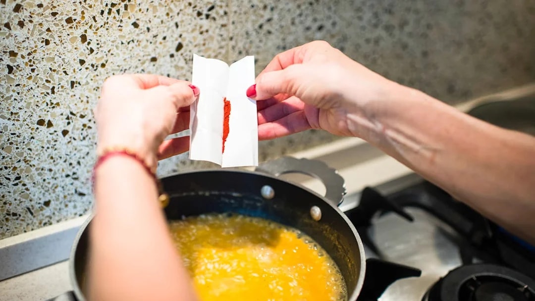 Adding spice to risotto during a private cooking class in Milan.