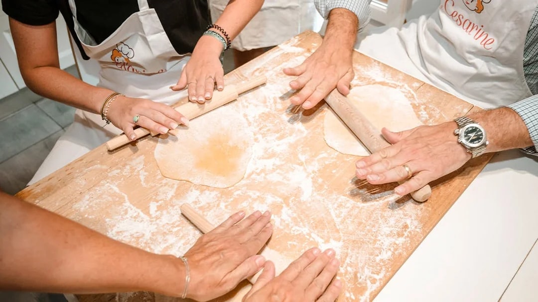 Participants rolling dough in a private cooking class in Milan.