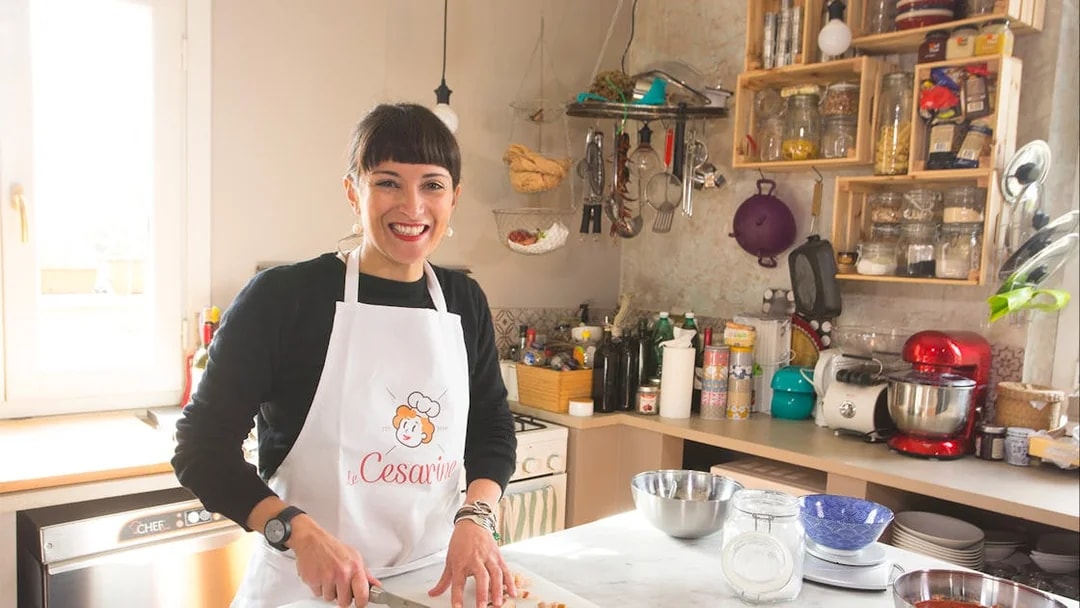 Person slicing bread during a private cooking class in a Rome kitchen.