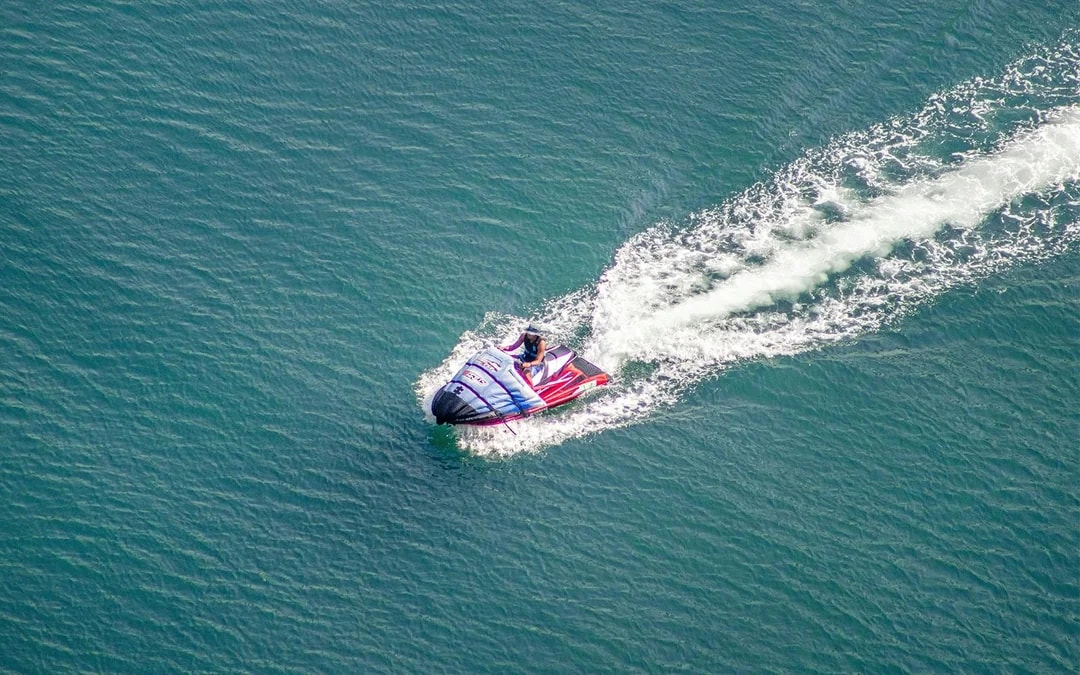 Aerial view of a jet skier navigating Dubai Marina waters.