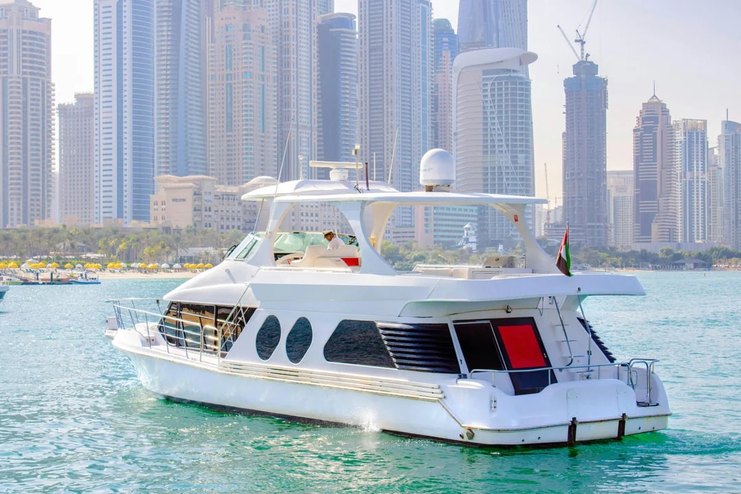Luxury yacht cruising in Dubai Marina with skyscrapers in the background.