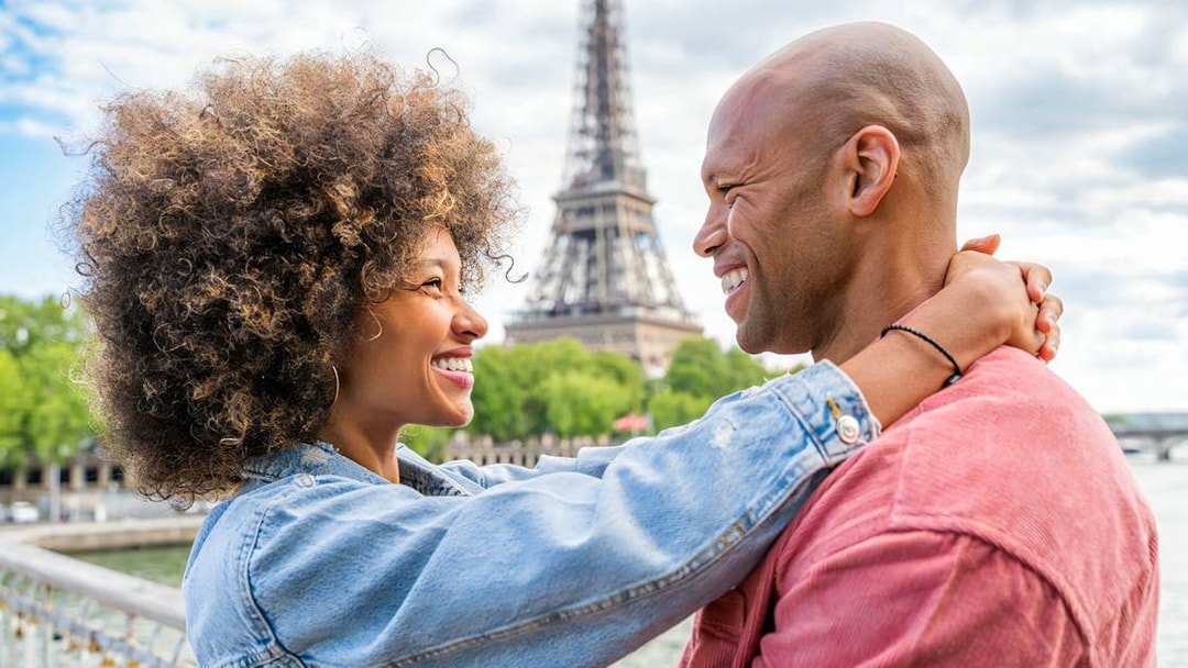Couple embracing with Eiffel Tower in background during private photoshoot in Paris.