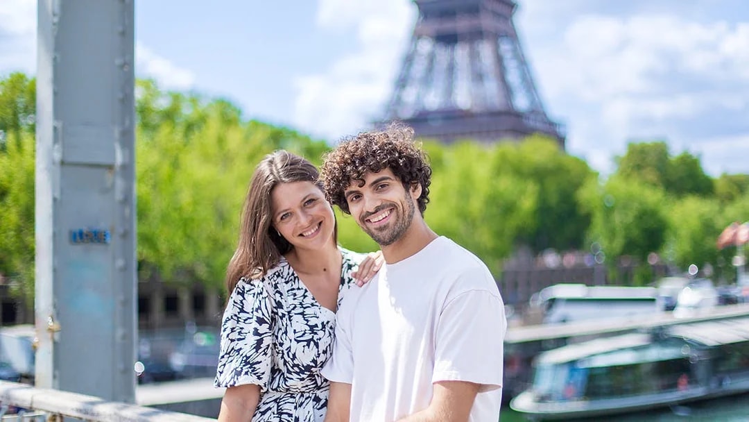Couple posing near Eiffel Tower during private photoshoot in Paris.