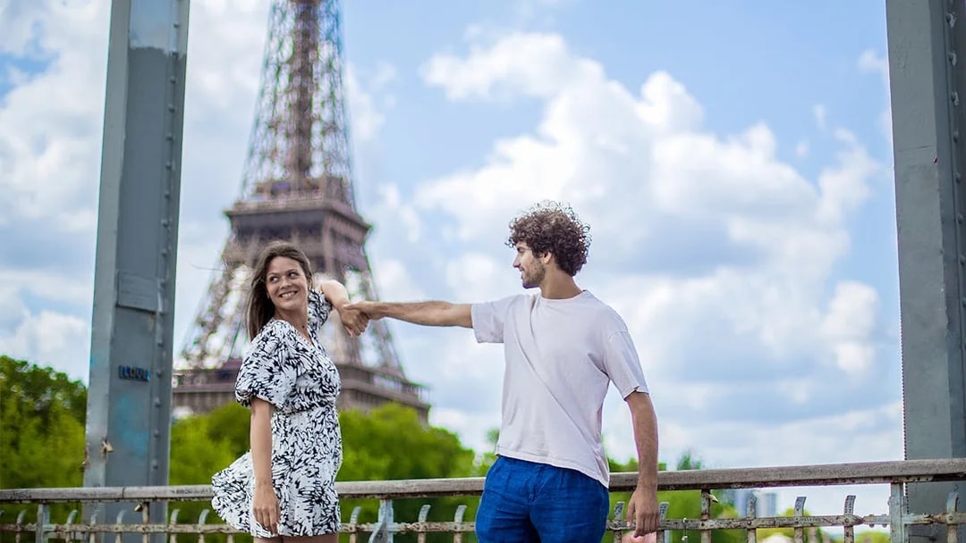 Couple posing near Eiffel Tower during private photoshoot in Paris.
