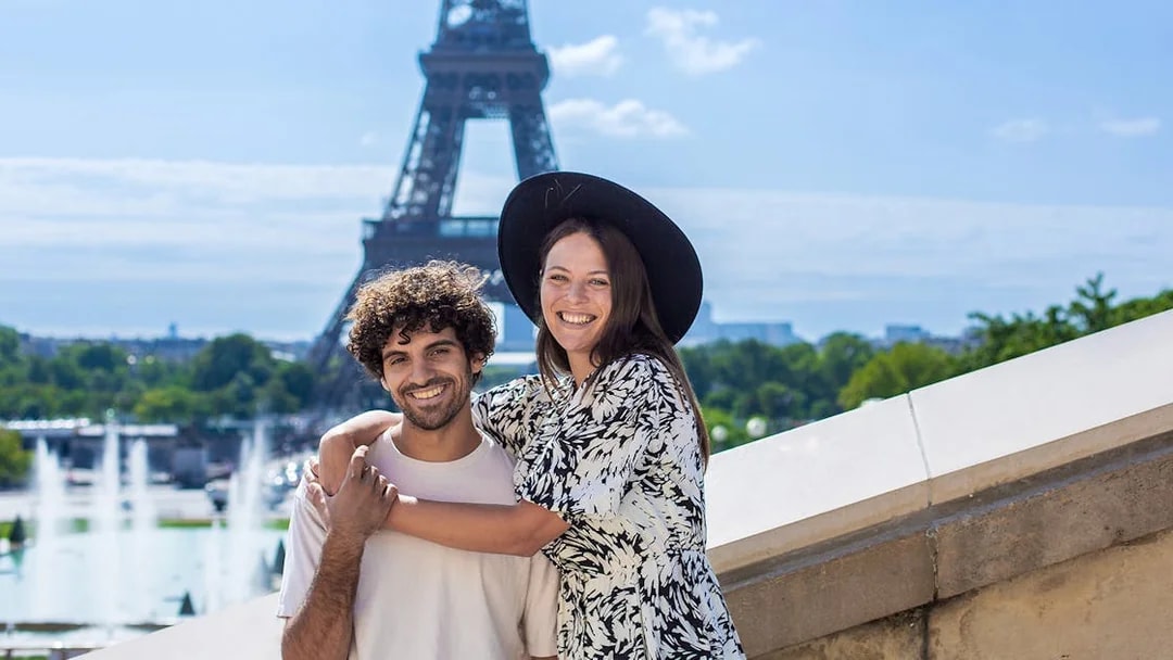 Couple posing in front of the Eiffel Tower during a private photoshoot in Paris.