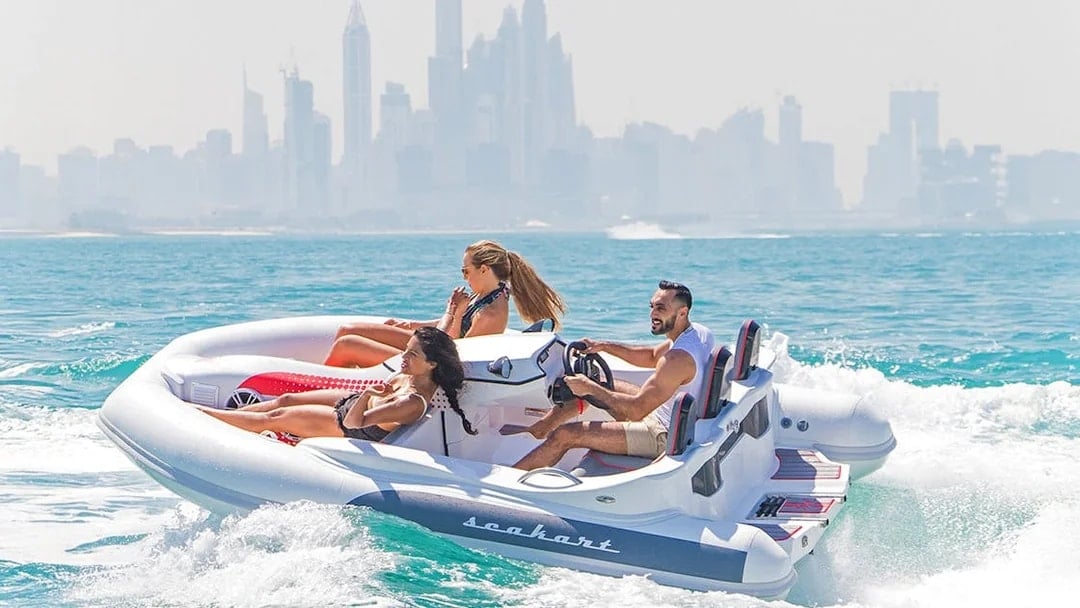 Group enjoying SeaKart jet ski tour in Dubai Marina with city skyline in background.