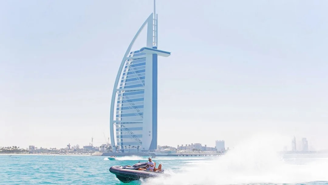 Tourist driving self-drive boat near Burj Al Arab in Dubai.