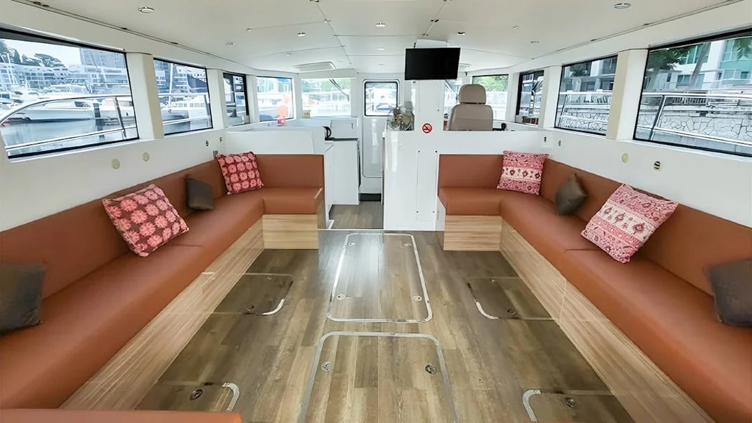 Interior of SunRise yacht with seating area and large windows at the marina.