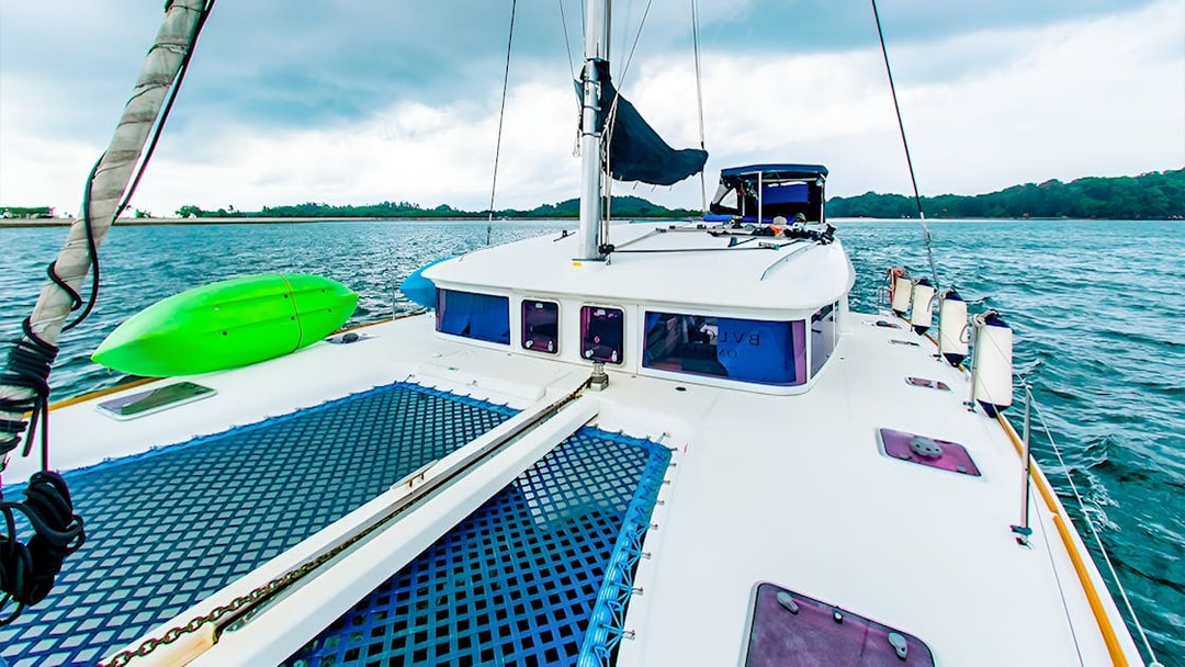 Private yacht charter deck with kayak on open sea.