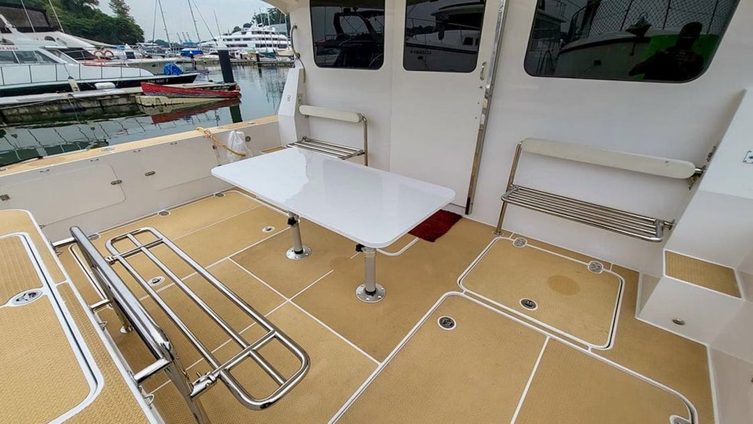 Private yacht SunRise deck with seating and table at marina.
