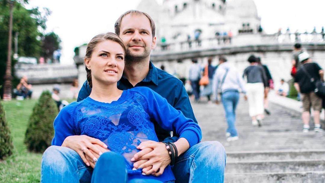 Couple sitting on Montmartre steps during professional photoshoot in Paris.