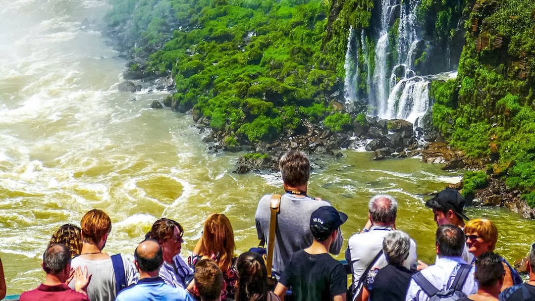 Visitors viewing Iguazu Falls from a platform in Brazil.