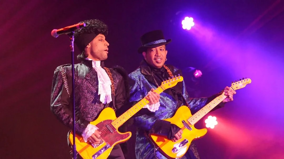 Musicians performing on stage with guitars under purple lighting, Purple Reign show.