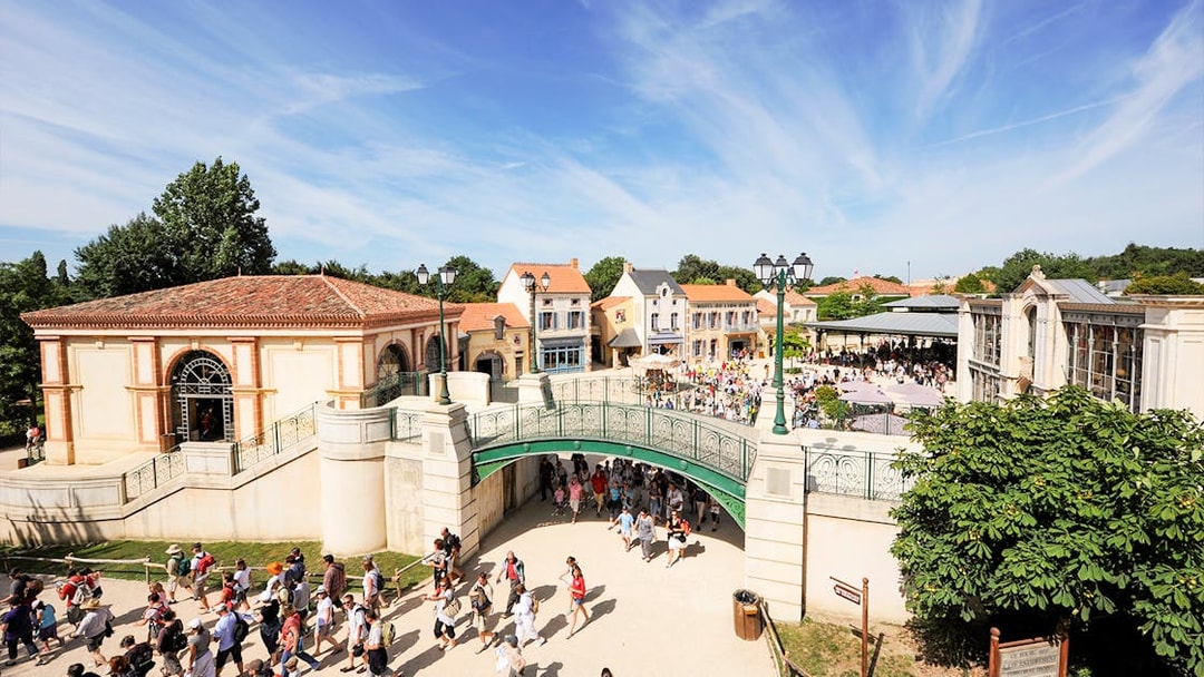 Visitors walking through Puy du Fou theme park entrance in France.