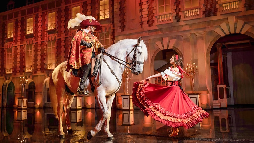 Performer on horseback and dancer in costume at Puy du Fou Theme Park show.