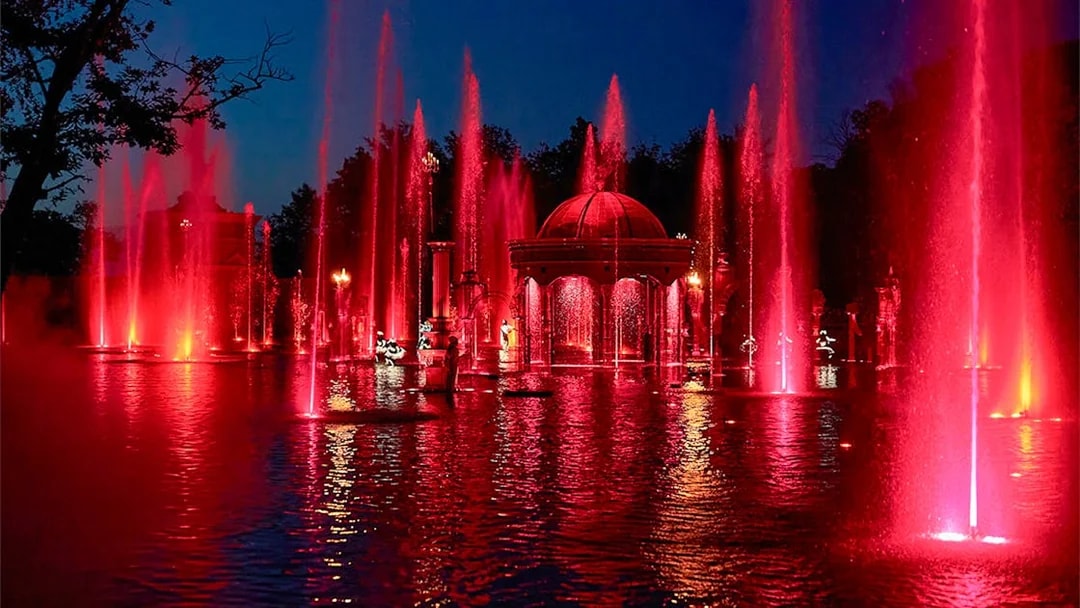 Fountain show at night with red lights at Puy du Fou Theme Park.