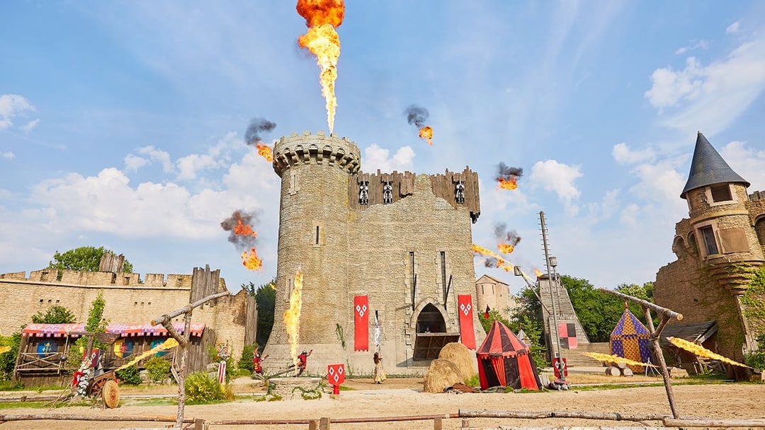 Medieval castle with fire effects at Puy du Fou Theme Park.