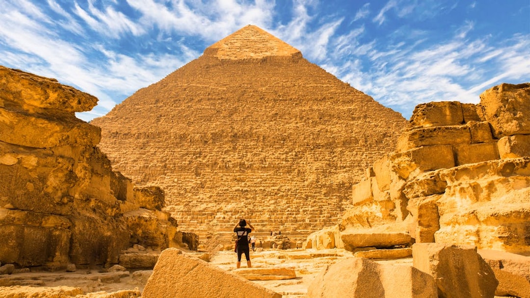 Pyramid of Giza with a person standing in front, part of a private quad and camel ride tour.