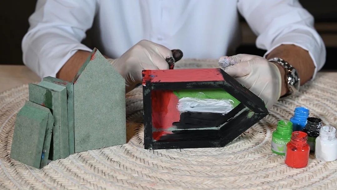 Crafting activity at Qasr Al Hosn with painted wooden blocks and paint jars.