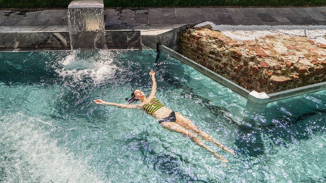 Visitor relaxing in the pool at QC Terme Milano Resort & Spa.