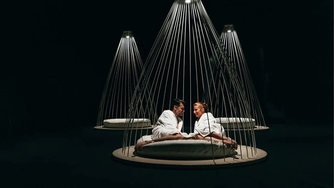 Couple relaxing in robes at QC Terme Milano Resort & Spa under modern lighting.