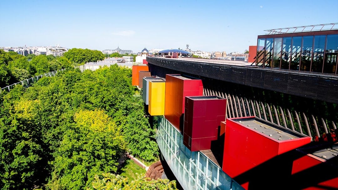 Musee du Quai Branly exterior with colorful facade and lush greenery in Paris.