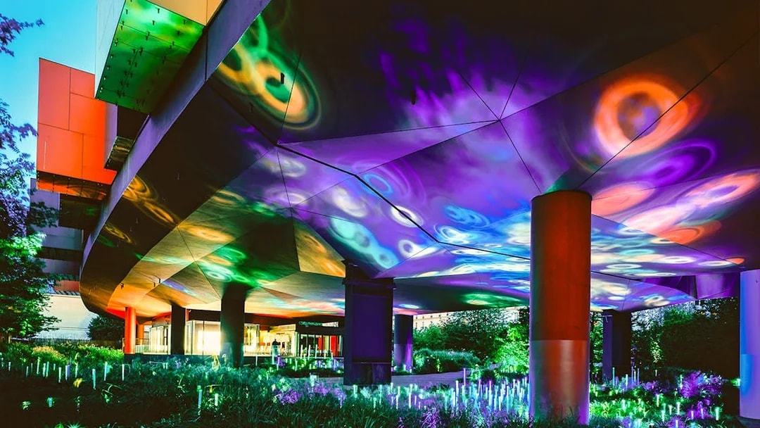 Colorful light display at night under the Musee du Quai Branly in Paris.