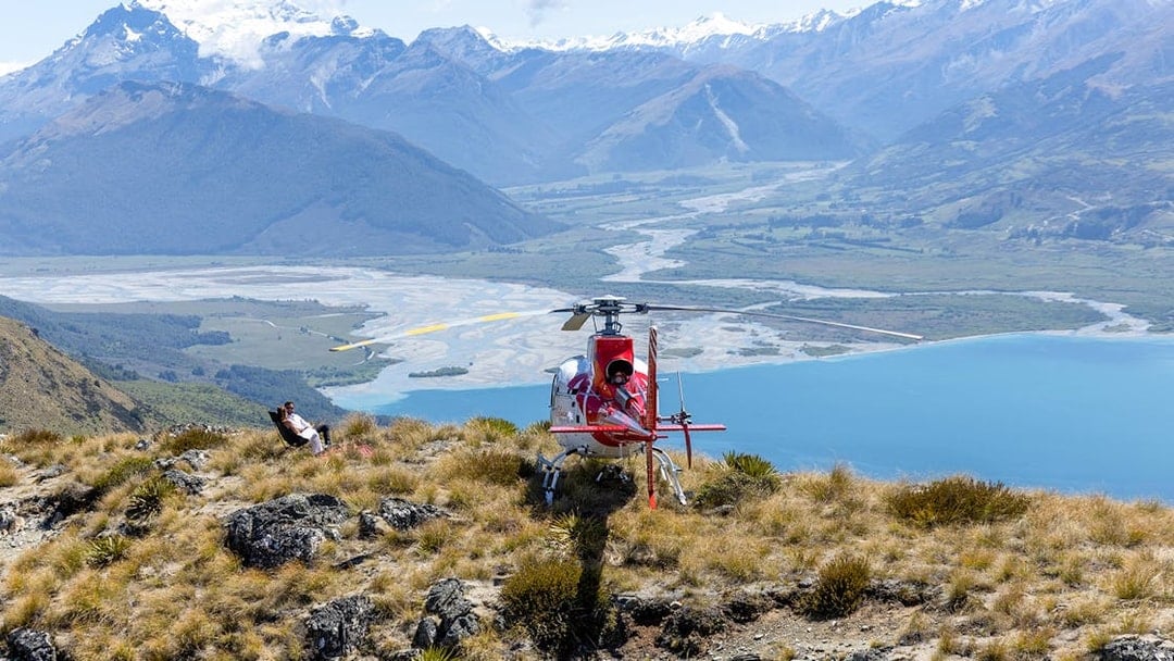 Helicopter landing on alpine terrain with mountain and river views, Milford Sound tour from Queenstown.