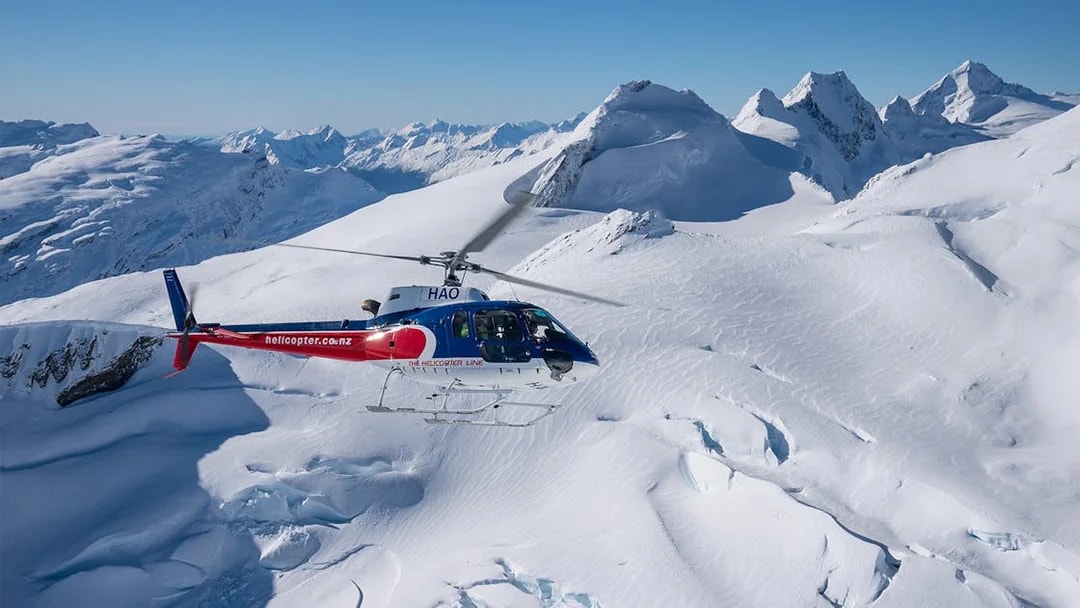 Helicopter flying over snowy mountains during Queenstown Panorama Helicopter Tour.