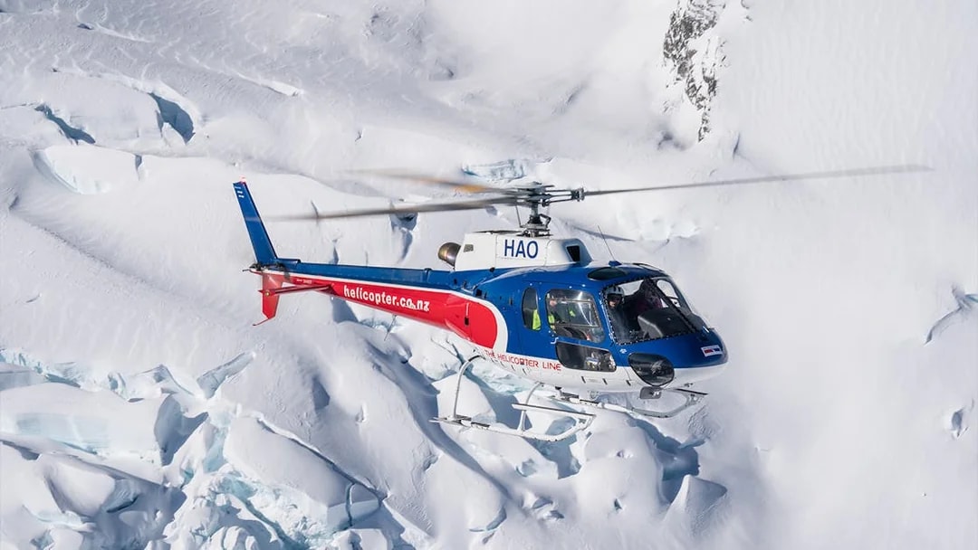 Helicopter flying over snowy alpine landscape during Queenstown Panorama Tour.