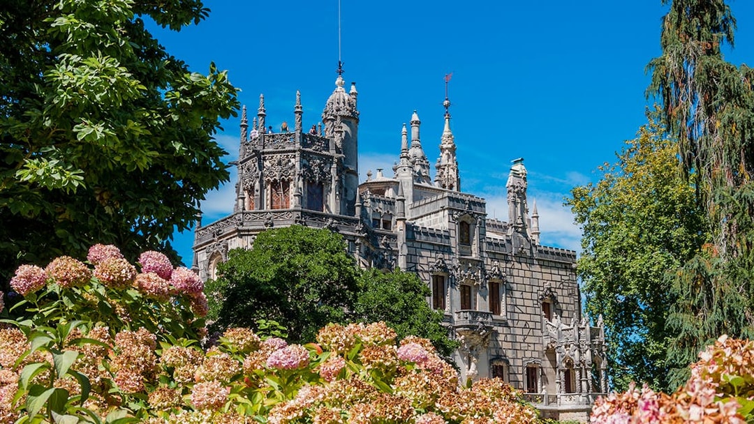 Quinta da Regaleira palace in Lisbon surrounded by lush gardens.