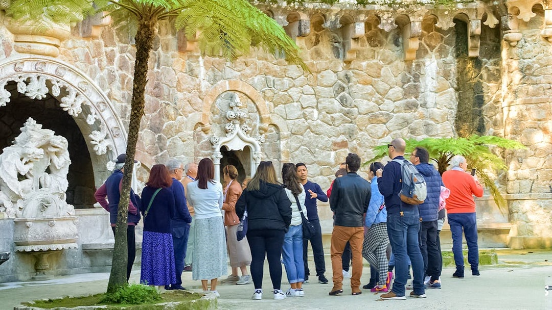 Tourists listening to a guide at Quinta de Regaleira Palace, Sintra.