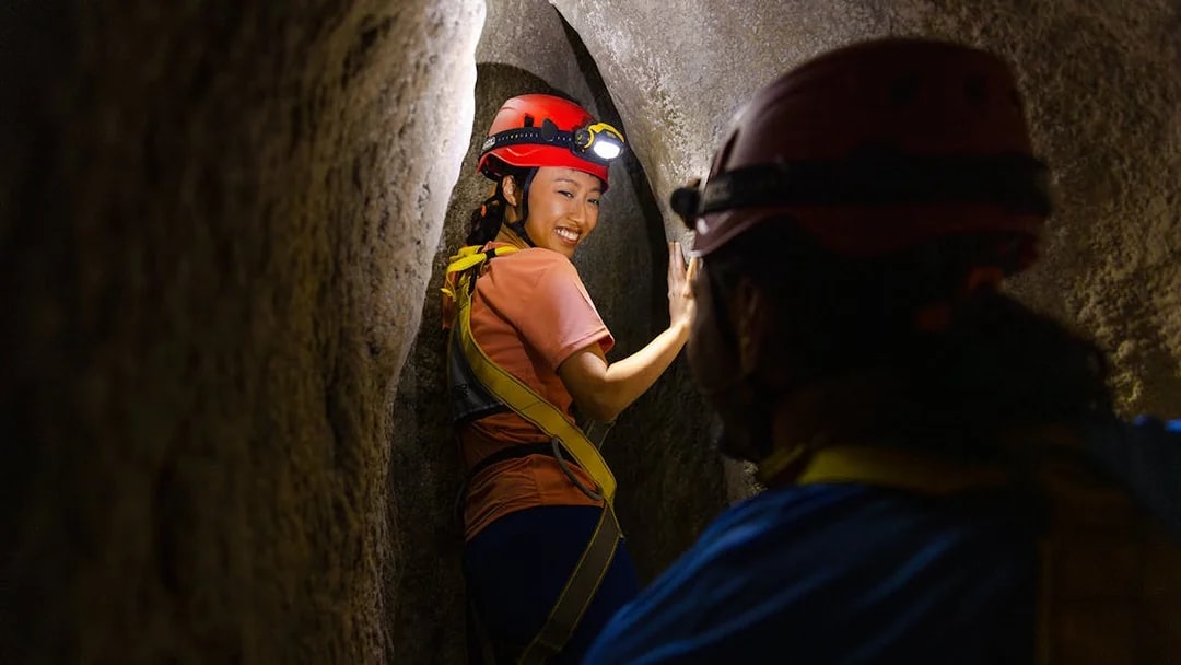 Adventurers exploring a narrow cavern in Rainforest Wild ASIA.