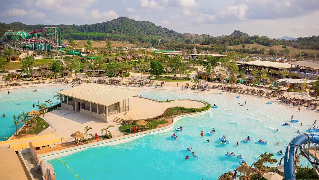 Visitors enjoying wave pool and slides at Ramayana Water Park, Thailand.