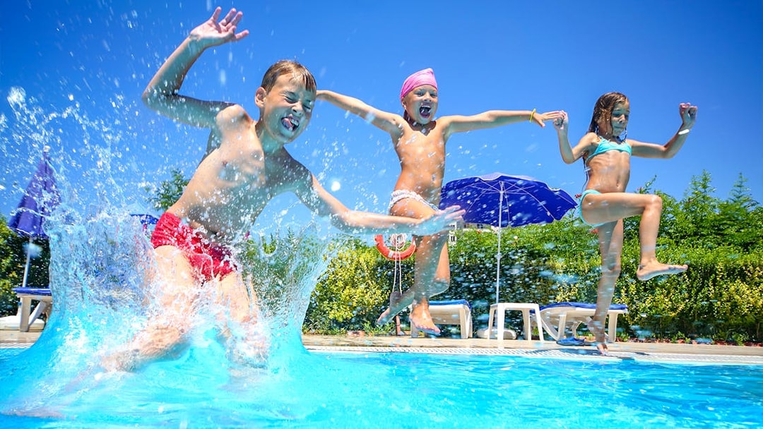 Children jumping into a pool at Ramayana Water Park, Thailand.