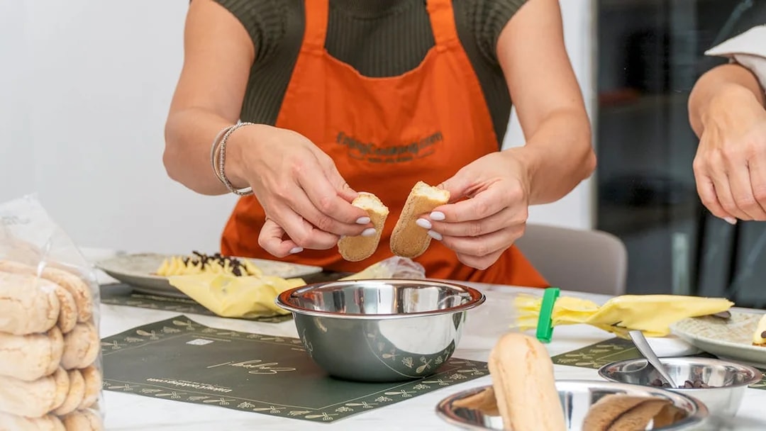 Hands preparing ingredients during a pasta making class.
