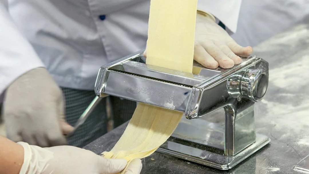Making pasta with a machine during a cooking class near the Colosseum.
