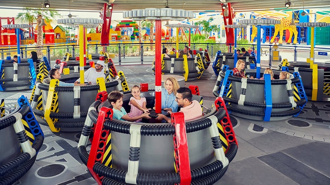 Children on the Disc-O-Saucers ride at Legoland Dubai, enjoying a family attraction.