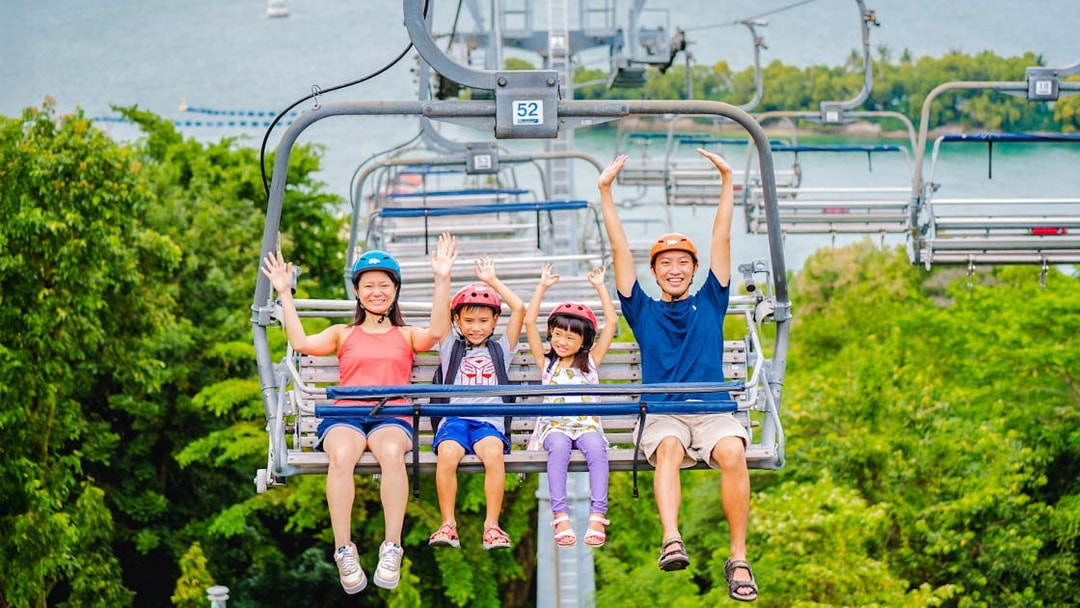 Family enjoying the Skyride in Singapore with lush greenery and ocean view.