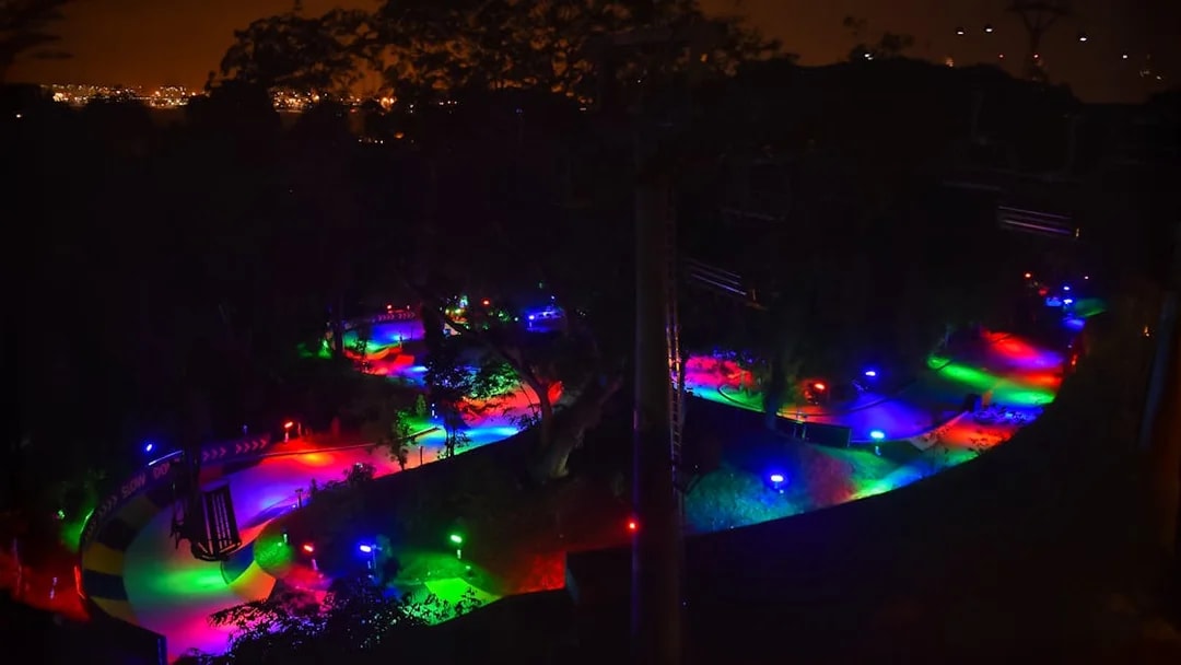 Night luge track illuminated with colorful lights in Singapore.