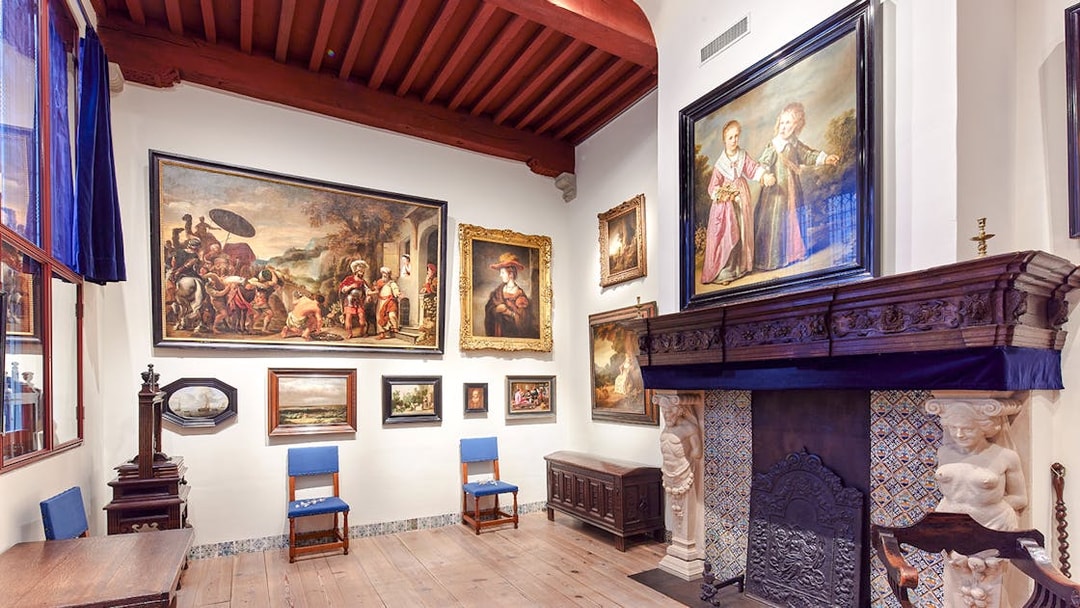 Rembrandt House Museum interior with paintings and ornate fireplace.